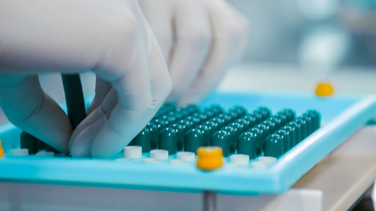 Manos con guantes trabajando en un laboratorio