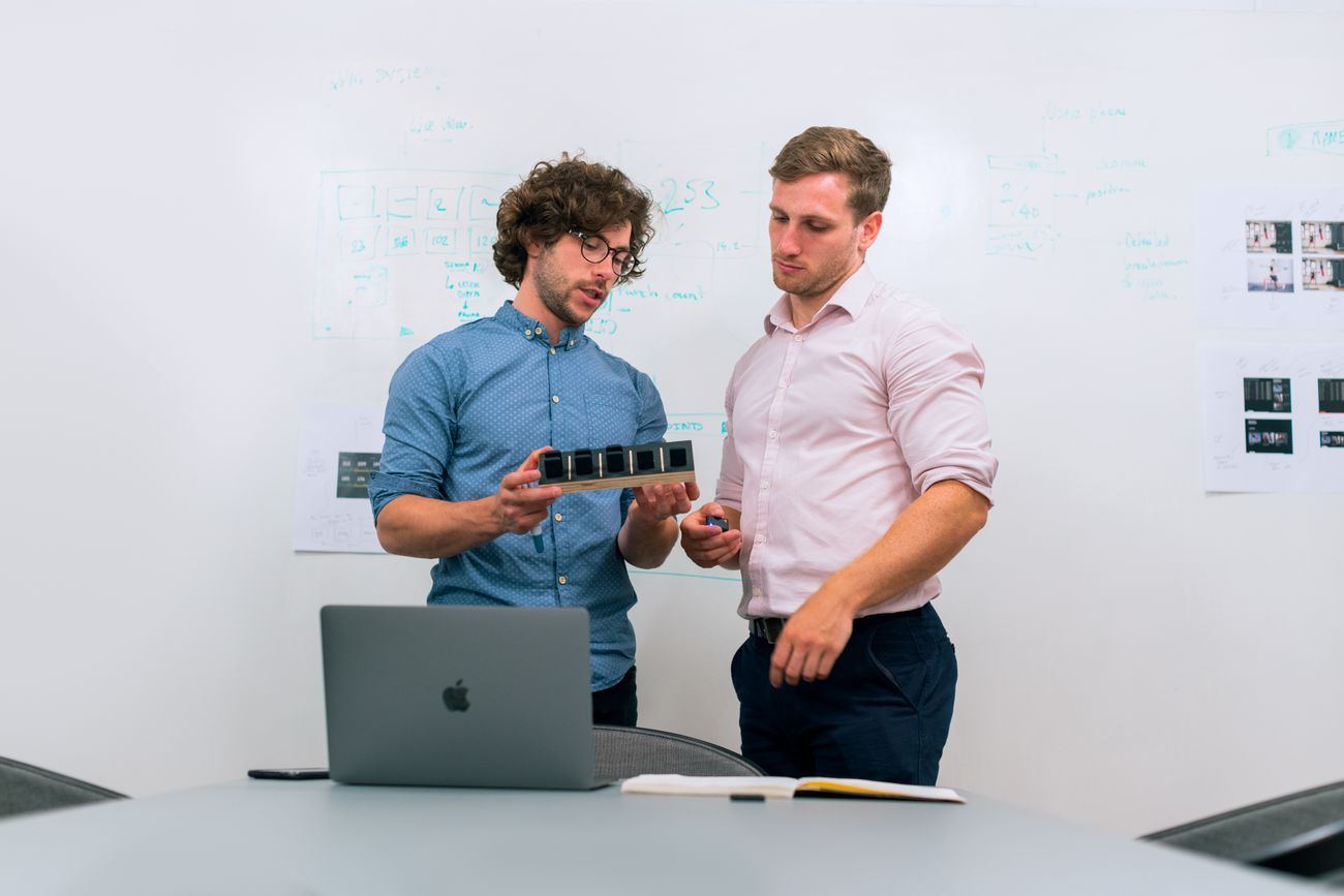 Ingenieros revisando avances frente a un pizarrón