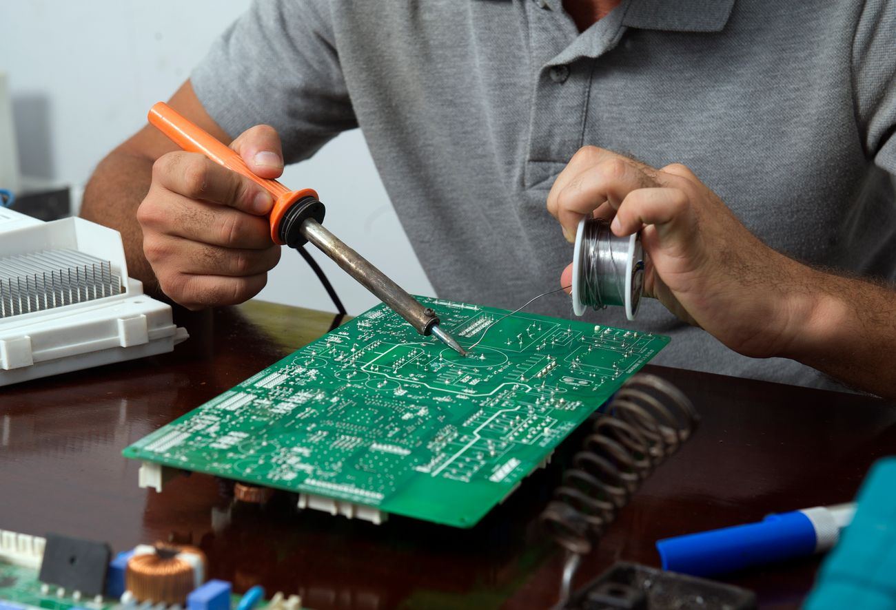 Técnico soldando una tarjeta electrónica