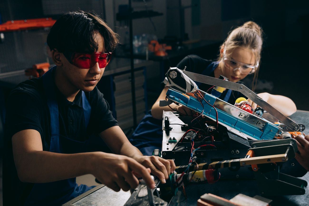 Jóvenes ingenieros trabajando en un equipo robótico