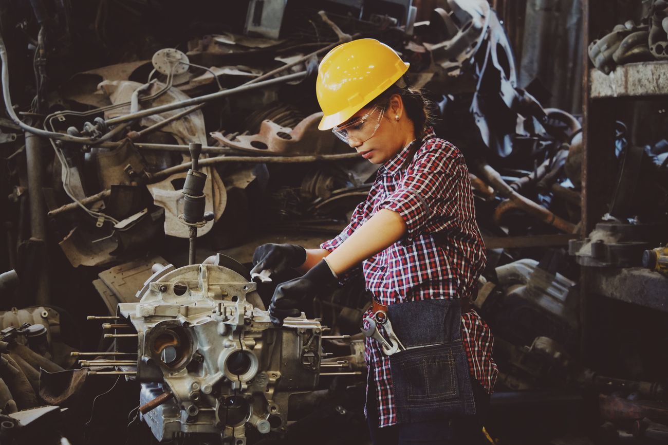 Técnica trabajando en un motor en planta